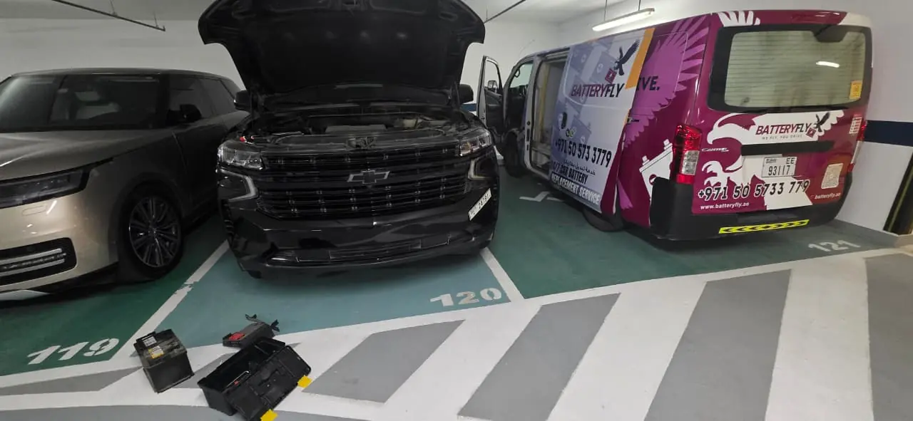 Batteryfly van servicing Chevrolet in Dubai parking – car battery replacement in progress