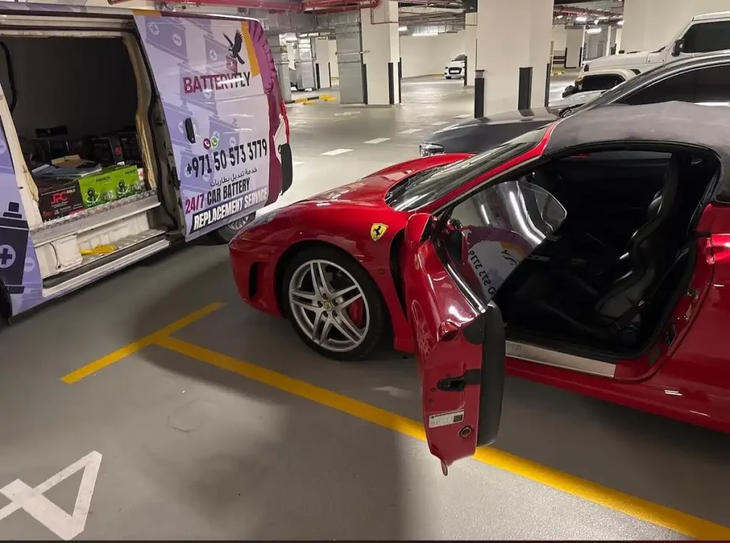 Batteryfly mobile service van beside a red Ferrari in an underground car park.